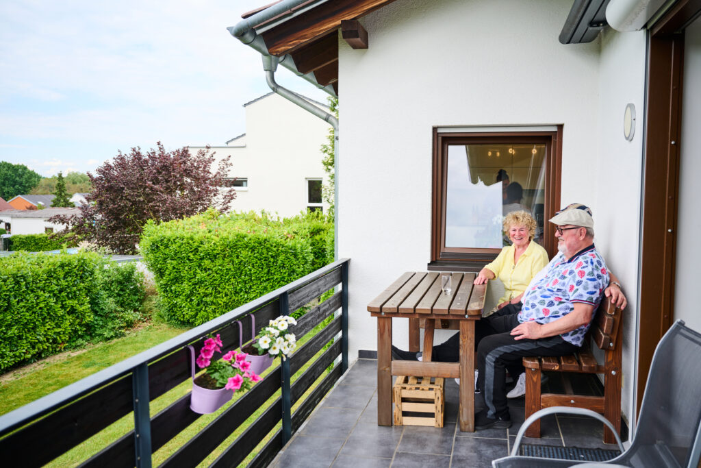 Bewohner sitzen zusammen auf Terrasse