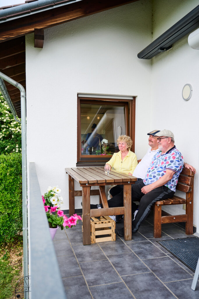 Bewohner sitzen zusammen auf der Terrasse